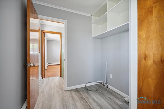 laundry room featuring a baseboard radiator, ornamental molding, and light wood-type flooring