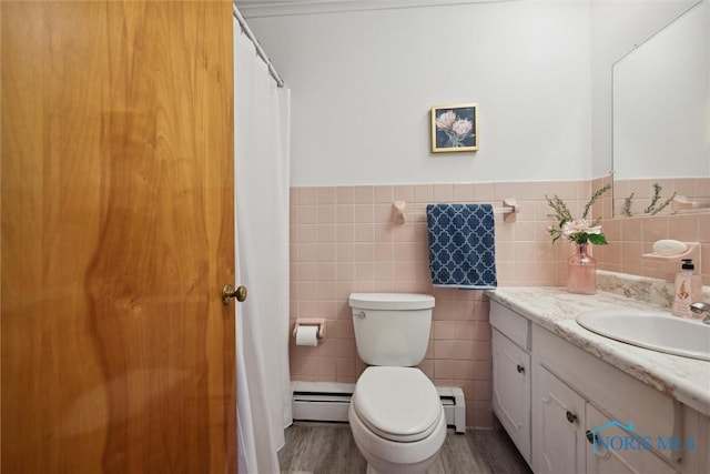 bathroom with vanity, toilet, tile walls, and a baseboard heating unit