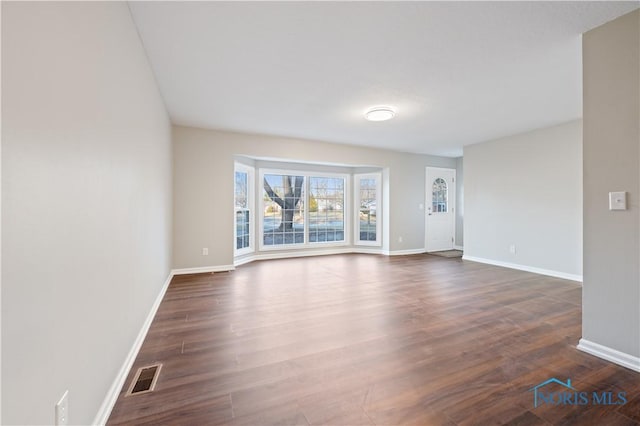 unfurnished living room featuring dark hardwood / wood-style flooring