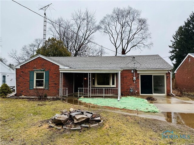 view of front of home featuring a garage, a front yard, and covered porch