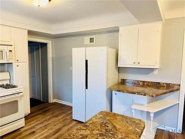 kitchen featuring white cabinetry, white appliances, dark hardwood / wood-style flooring, and dark stone countertops