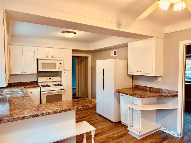 kitchen with sink, white appliances, white cabinetry, dark hardwood / wood-style flooring, and kitchen peninsula