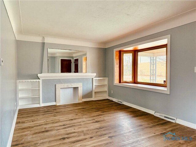 unfurnished living room featuring a fireplace and hardwood / wood-style floors