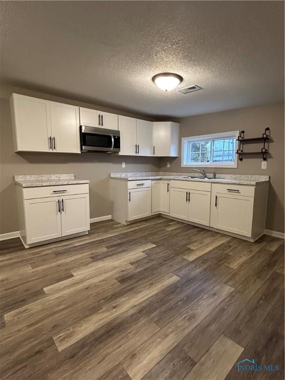 kitchen with white cabinetry, sink, and dark hardwood / wood-style floors