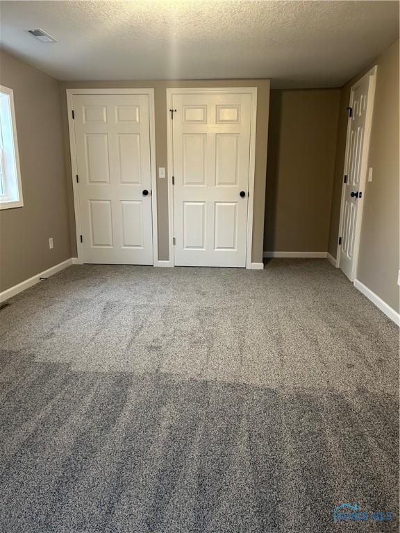 unfurnished bedroom with carpet and a textured ceiling