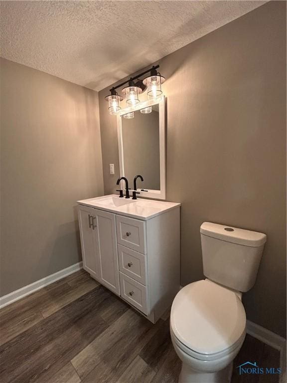 bathroom with vanity, hardwood / wood-style floors, a textured ceiling, and toilet