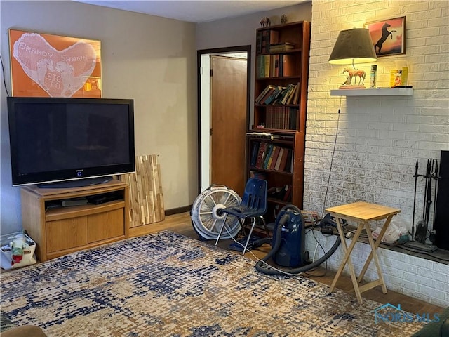 interior space featuring baseboards, brick wall, and wood finished floors