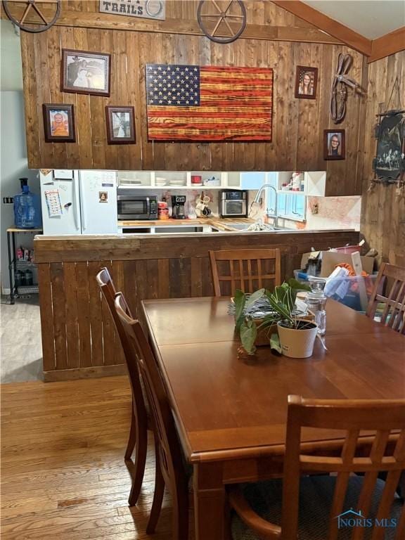 dining room with wood walls and wood finished floors