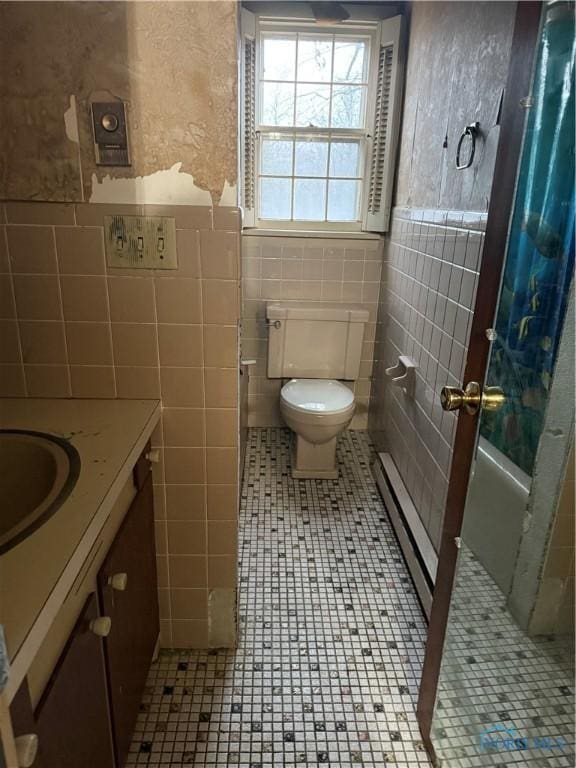 bathroom with toilet, tile patterned floors, tile walls, and vanity