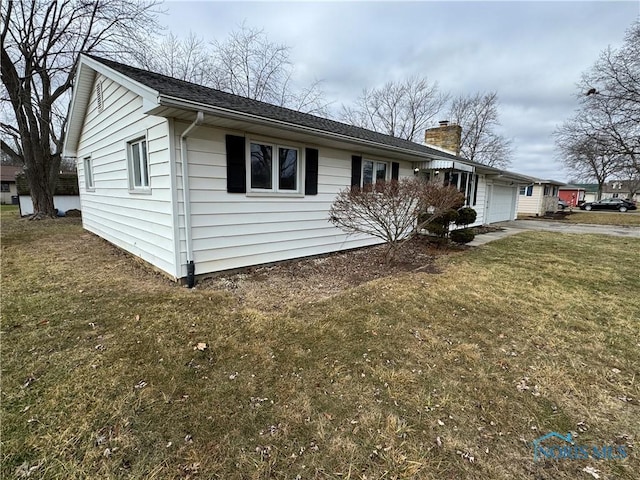 view of front of property with a garage and a front lawn