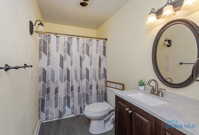 bathroom featuring vanity, wood-type flooring, toilet, and a shower with shower curtain