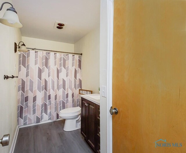 bathroom featuring vanity, hardwood / wood-style floors, and toilet