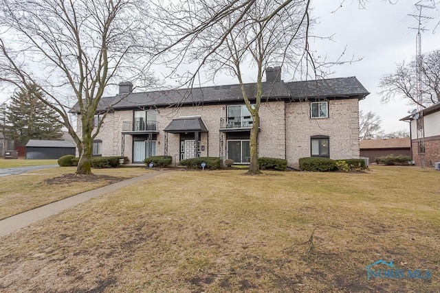 view of front of house featuring a front lawn and a balcony