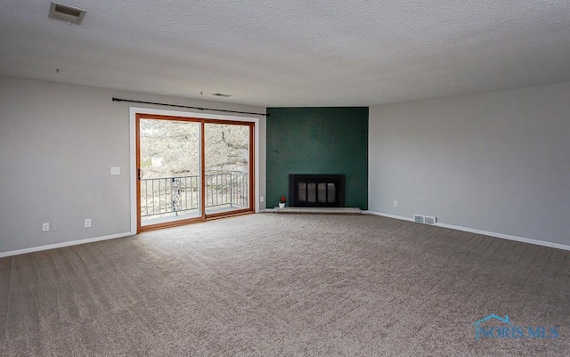 unfurnished living room featuring a large fireplace, a textured ceiling, and carpet