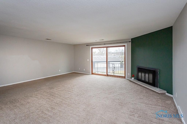 unfurnished living room featuring carpet flooring, a fireplace, and a textured ceiling