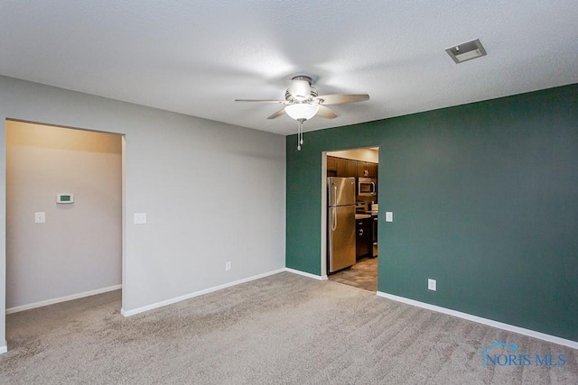 carpeted spare room with ceiling fan