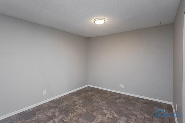 unfurnished room with a textured ceiling