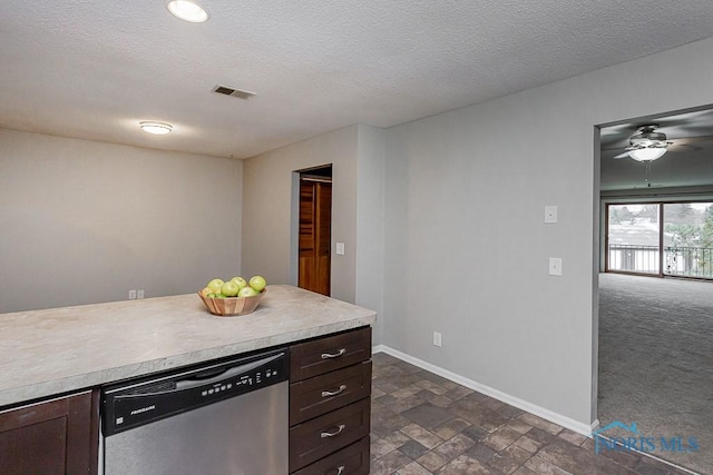 kitchen featuring stainless steel dishwasher, dark carpet, dark brown cabinets, and a textured ceiling