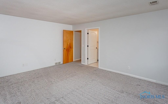 carpeted empty room featuring a textured ceiling