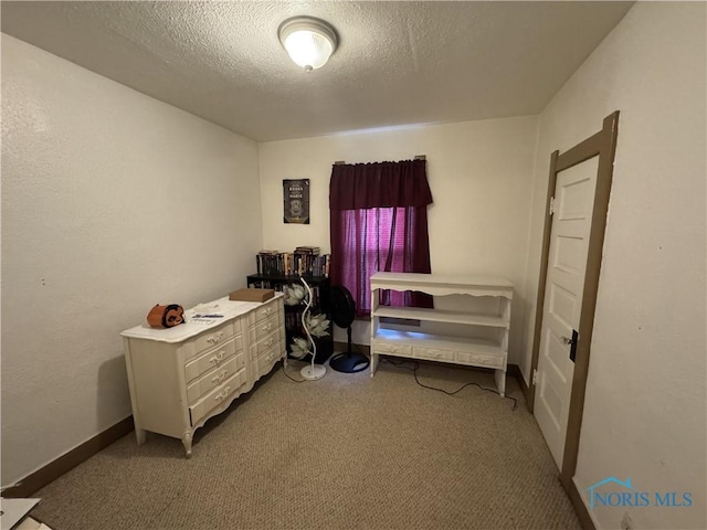 bedroom featuring light carpet and a textured ceiling