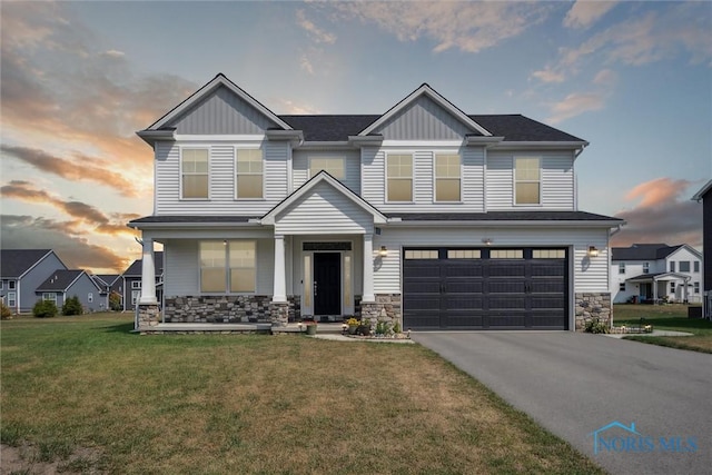 craftsman inspired home with a garage and a lawn