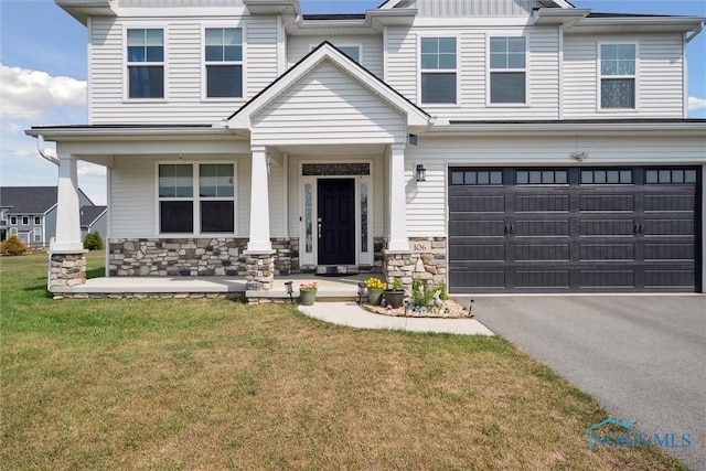 view of front facade with a porch, a garage, and a front lawn