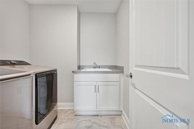 washroom with cabinets, sink, and washing machine and clothes dryer