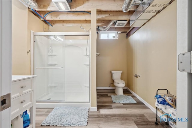 bathroom with hardwood / wood-style flooring, vanity, toilet, and a shower with shower door