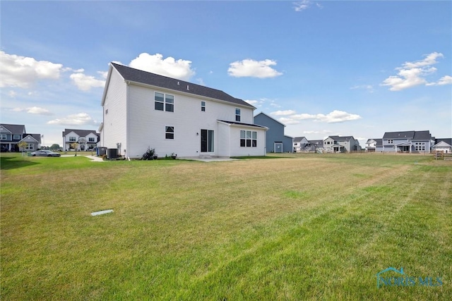 rear view of property featuring a yard and central air condition unit