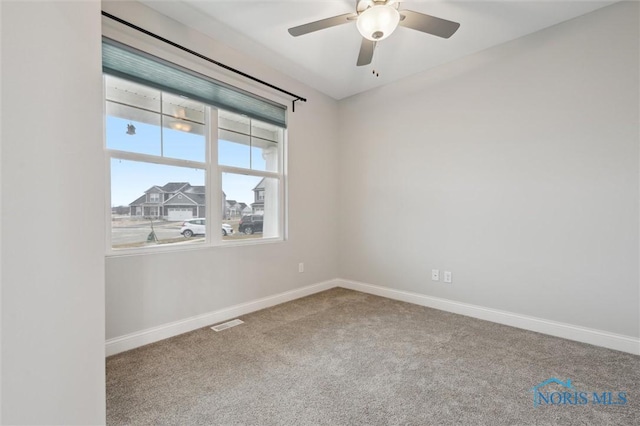 carpeted spare room featuring ceiling fan