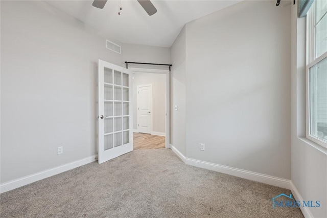 unfurnished bedroom featuring light carpet, french doors, and ceiling fan