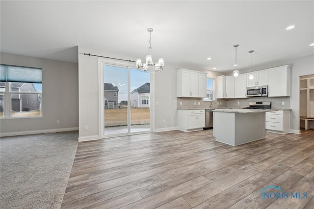 kitchen featuring white cabinetry, pendant lighting, and stainless steel appliances