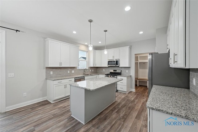 kitchen featuring appliances with stainless steel finishes, a kitchen island, and white cabinets