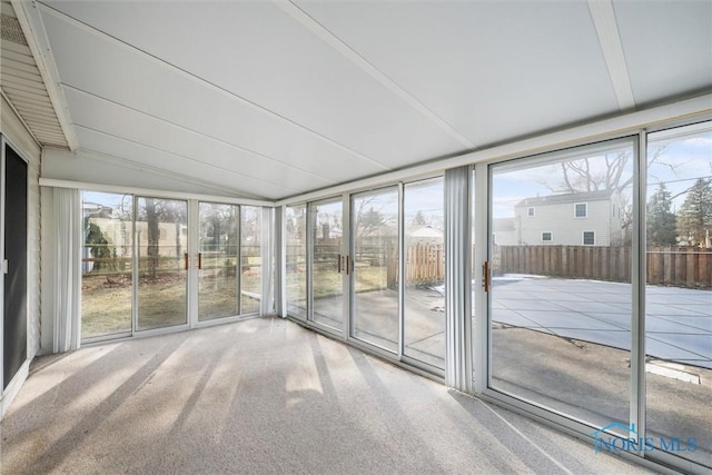 unfurnished sunroom featuring lofted ceiling