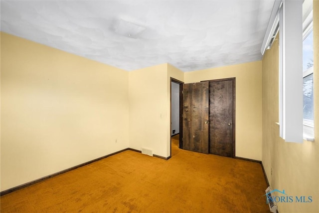 unfurnished bedroom with a closet and light carpet