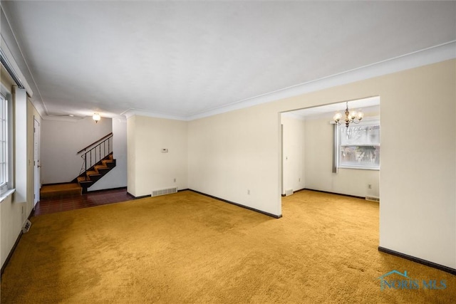 unfurnished room featuring an inviting chandelier, ornamental molding, and carpet floors