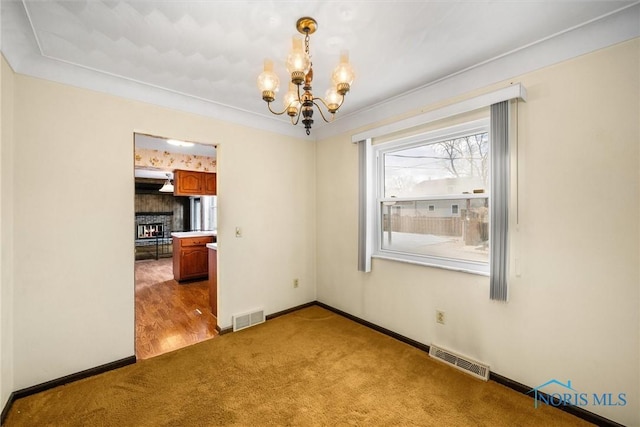 unfurnished room with light colored carpet and a notable chandelier