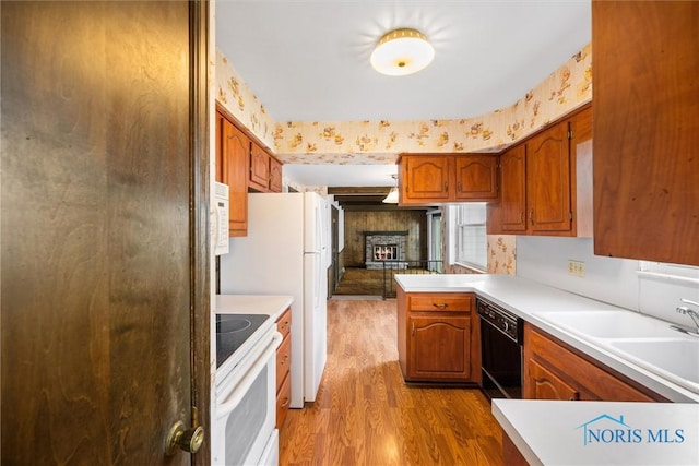 kitchen with sink, light hardwood / wood-style flooring, dishwasher, white stove, and kitchen peninsula