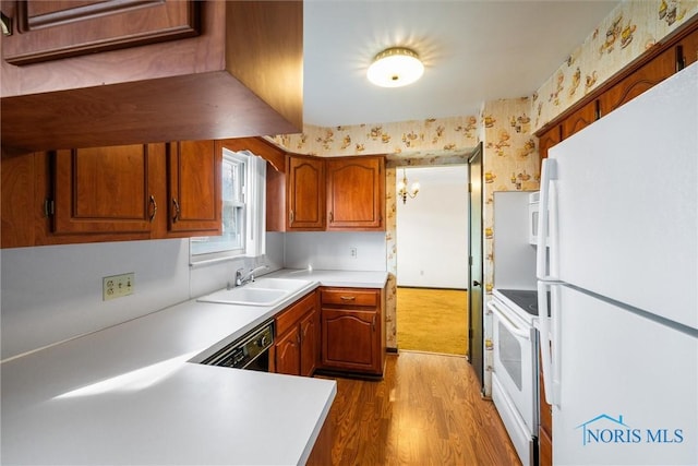 kitchen with sink, white appliances, and light wood-type flooring