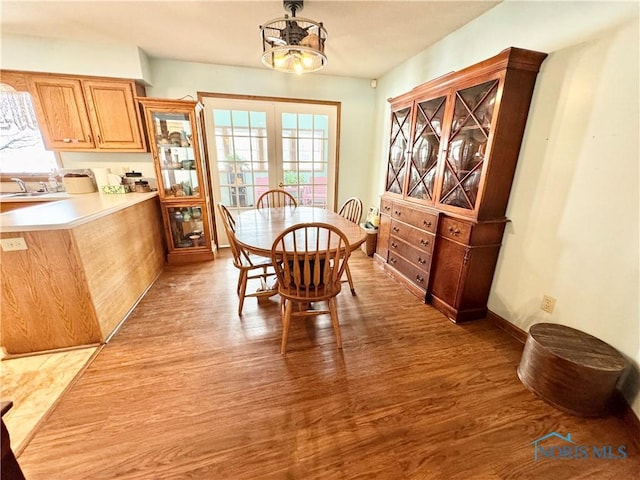 dining room with french doors and light hardwood / wood-style floors