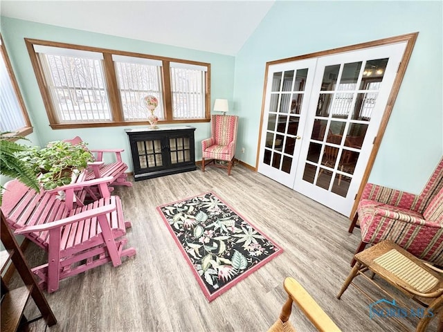 living area featuring french doors, hardwood / wood-style flooring, and lofted ceiling