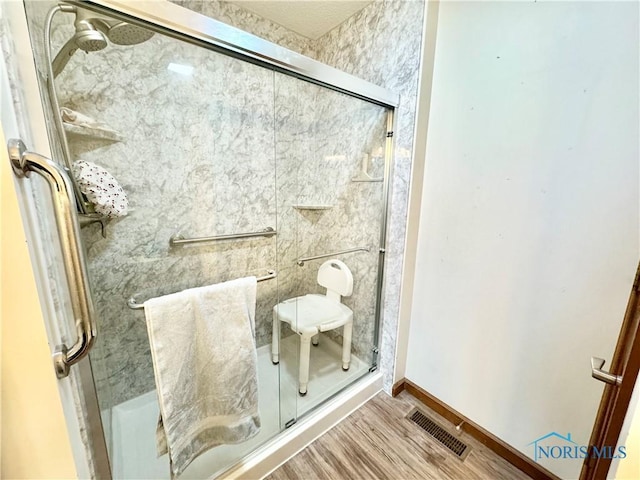 bathroom featuring hardwood / wood-style flooring and a shower with shower door