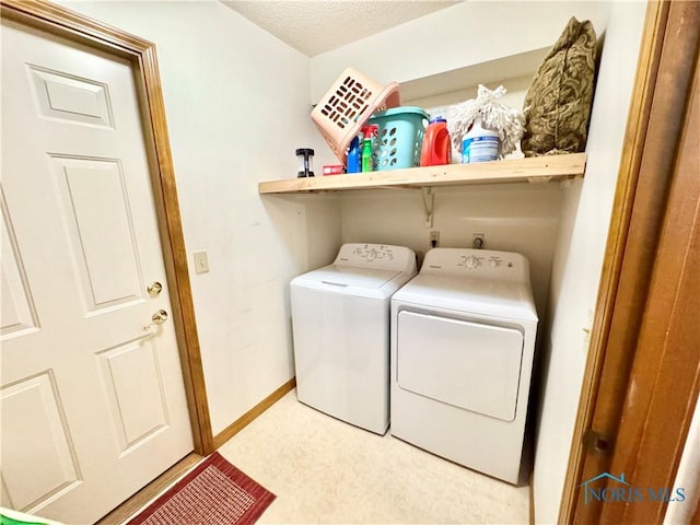 laundry room featuring washing machine and dryer and a textured ceiling