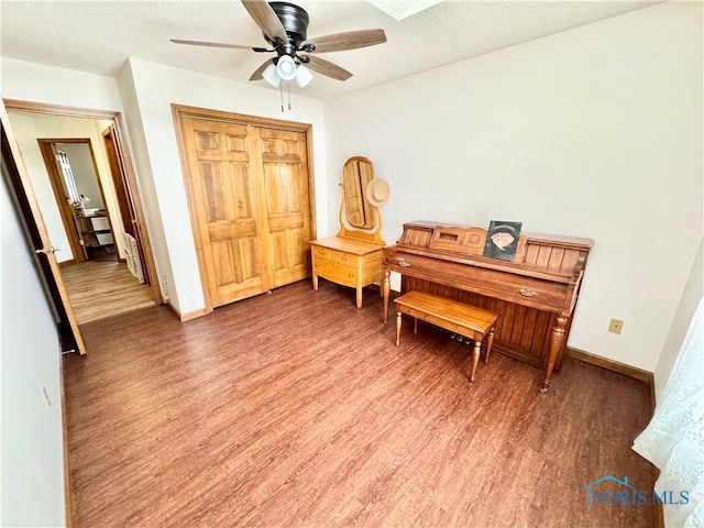 sitting room with hardwood / wood-style floors and ceiling fan