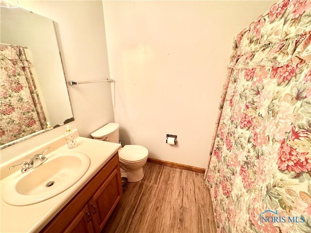 bathroom featuring toilet, hardwood / wood-style flooring, and vanity