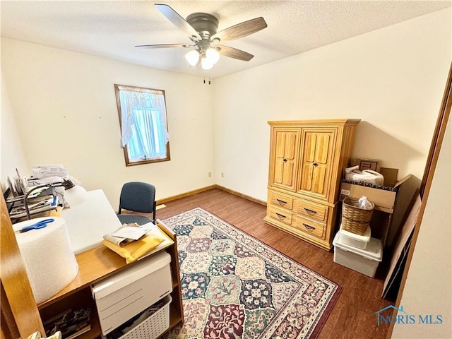 office with dark hardwood / wood-style flooring, ceiling fan, and a textured ceiling