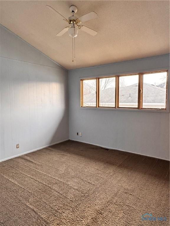 empty room featuring lofted ceiling, a textured ceiling, ceiling fan, and carpet flooring