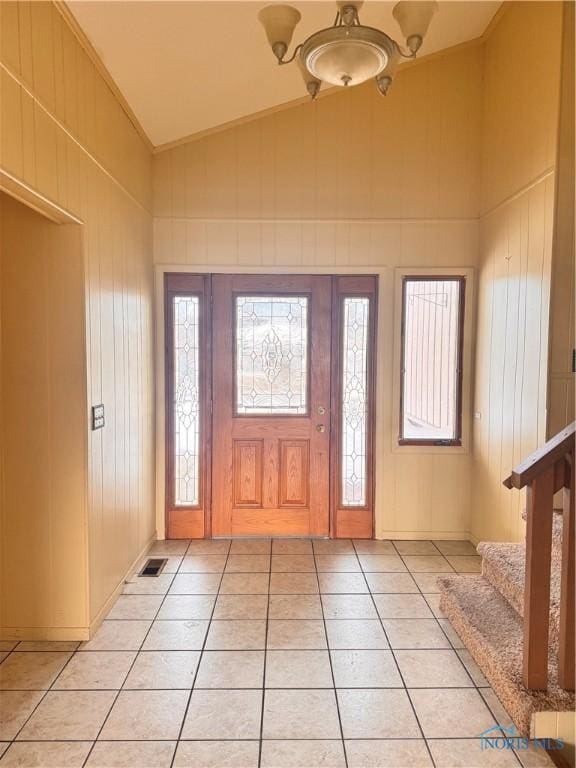 foyer entrance featuring vaulted ceiling, a healthy amount of sunlight, and light tile patterned floors