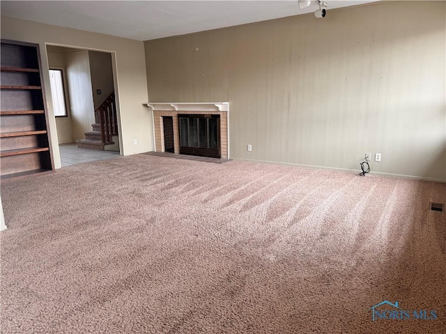 unfurnished living room featuring light colored carpet and a fireplace