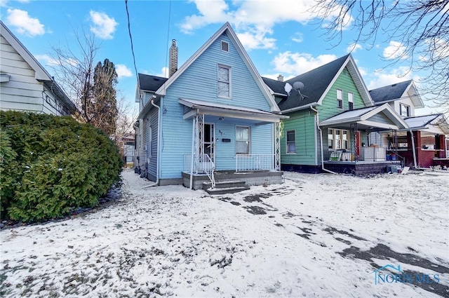 snow covered property featuring covered porch